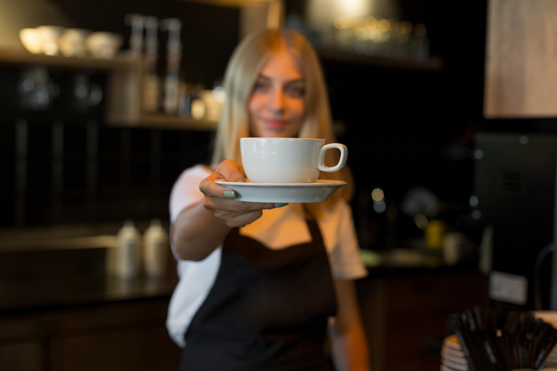 Female barista giving coffee