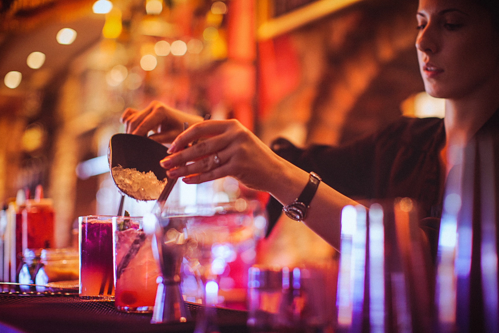 Midsection of young female bartender preparing cocktails in cocktail bar